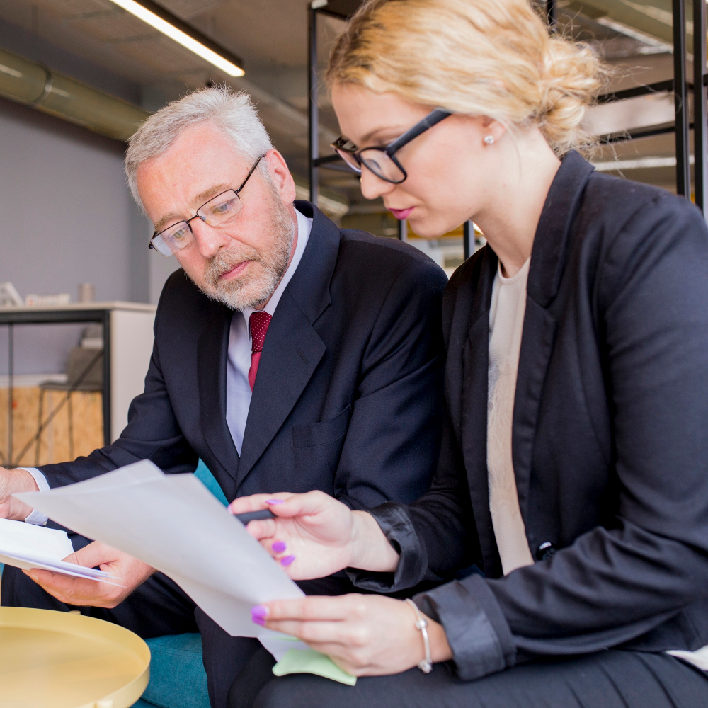 Two paralegals reviewing papers together in a modern office.